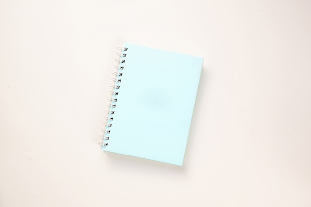 Hellblaues Notizbuch auf rosa Hintergrund