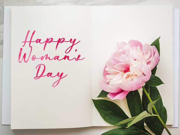 Helle Blumen und Happy Women's Day Schriftzug. Nahaufnahme, keine Menschen, Textur. Herzlichen Glückwunsch für Familie, Verwandte, Freunde und Kollegen