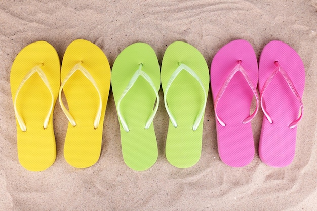 Helle Flipflops auf Sand hautnah