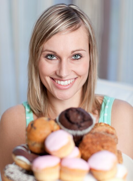 Helle Frau, die eine Platte von Kuchen hält