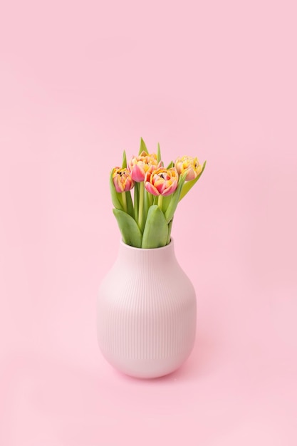 Helle frische Blumen in einer rosa Vase auf einem rosa Hintergrund