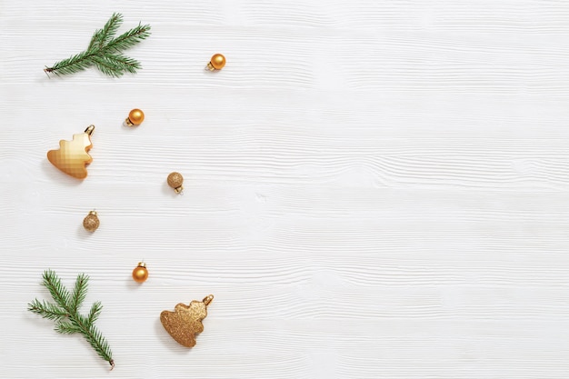 Helle glänzende kleine Weihnachtskugeln goldfarben mit natürlichem grünem Tannenzweig, Neujahrsdekor