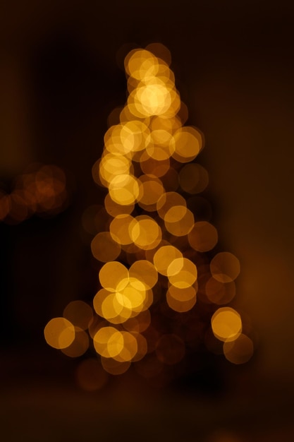 Helle goldene Bokeh-Lichter in Neujahrsbaumform wie Überlagerung für Ihr Weihnachtsdesign