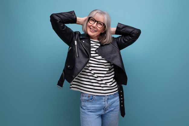 Helle, grauhaarige, reife Frau in einer stylischen Jacke auf hellem Hintergrund mit Kopierraum