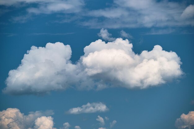 Helle Landschaft aus weißen geschwollenen Kumuluswolken am blauen klaren Himmel.