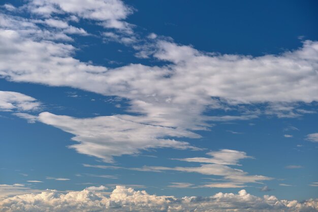 Helle Landschaft aus weißen geschwollenen Kumuluswolken am blauen klaren Himmel.