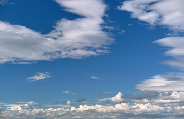 Helle Landschaft aus weißen geschwollenen Kumuluswolken am blauen klaren Himmel.