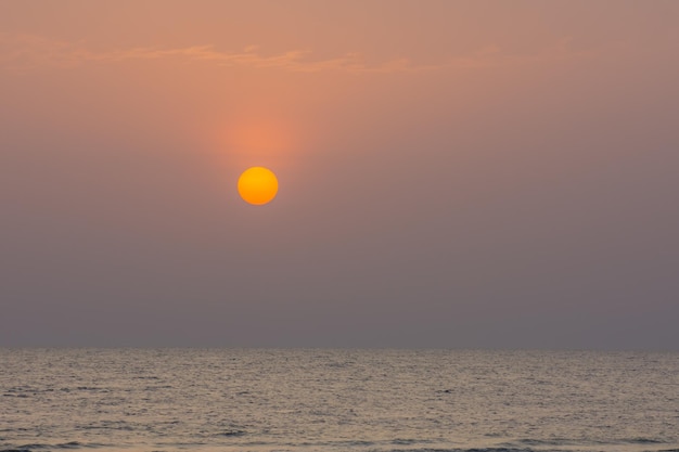 Helle orangefarbene Sonne am Strand im Urlaub