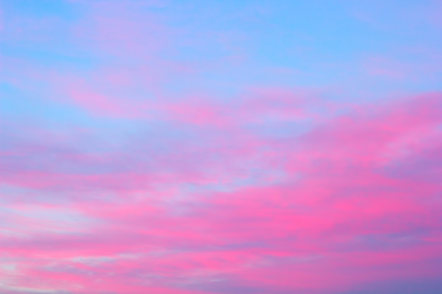 Helle rosa Wolken auf einem blauen Himmel bei dem Sonnenuntergang