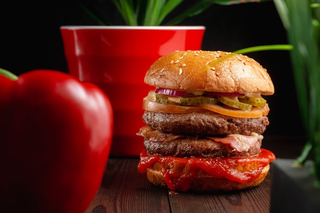 Helle saftige gegrillte Burger mit Pilzen und marinierten Gurken auf hölzernem Hintergrund. Fast-Food-Konzept