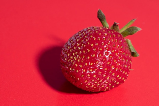 Helle saftige reife Erdbeeren auf einem roten Hintergrund. Vorderansicht, gesundes Essen, Vegetarismus