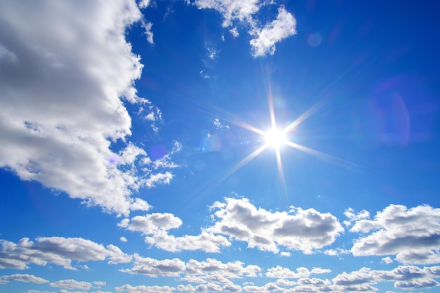 Helle, sommerliche, schwüle Sonne gegen blauen Himmel und weiße Wolken des Hintergrundes.