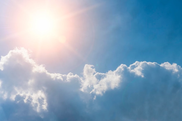 Helle Sonne am blauen Himmel mit weißem, flauschigem Wolkenhintergrund