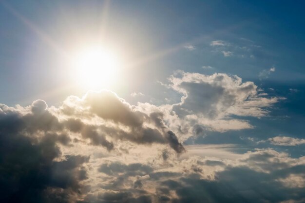 Foto helle sonne über dunklen wolken am blauen himmel