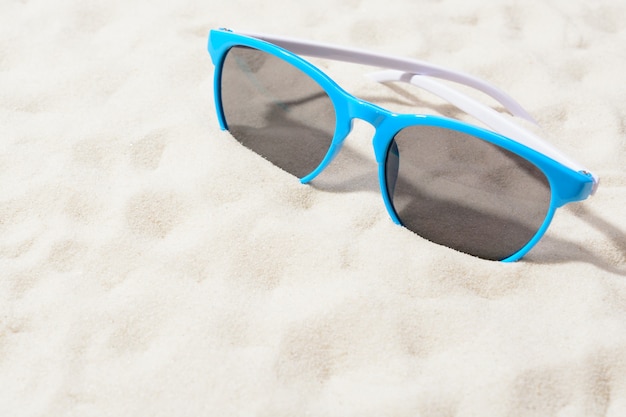 Helle Sonnenbrille auf Sand