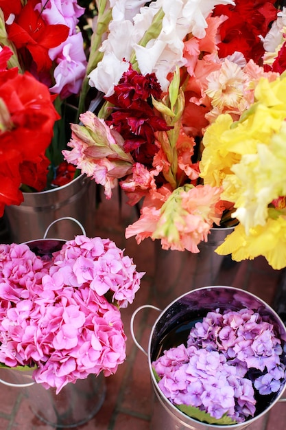 Helle verschiedene Blumen in Eisenbehältern in einem Blumenladen in der Nähe