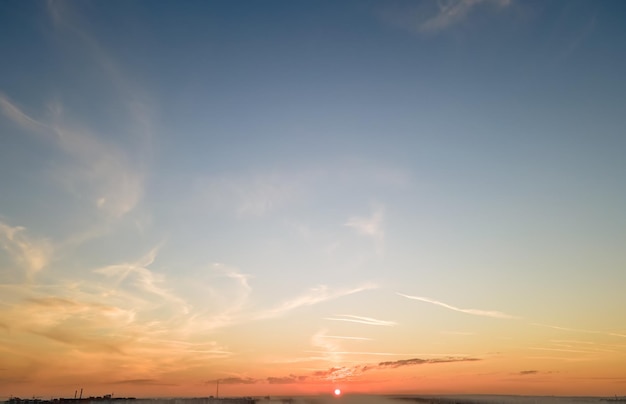 Heller bunter Sonnenunterganghimmel mit untergehender Sonne und lebendigen weichen Wolken Konzept von Natur und Umwelt