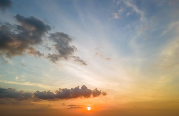 Heller bunter Sonnenunterganghimmel mit untergehender Sonne und lebendigen Wolken.