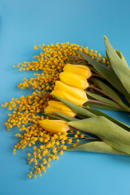 Heller Frühlingsstrauß aus Tulpen und Mimosenblumen