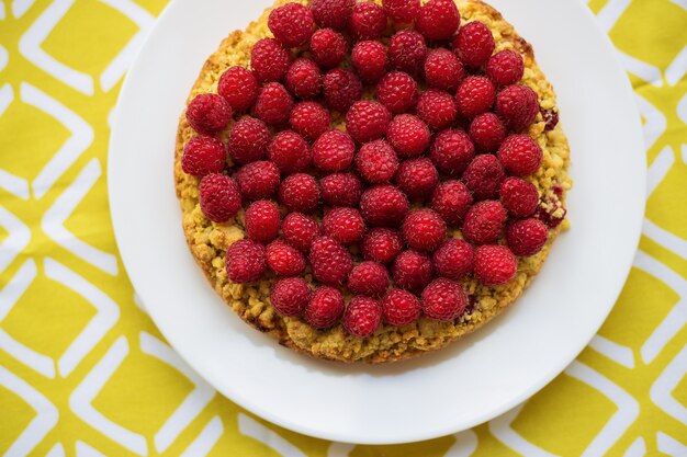 Heller hochroter Sandkuchen auf gelber Serviette, Draufsicht