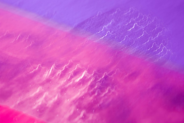 Heller mehrfarbiger abstrakter Hintergrund. Tropfen auf einer glänzenden Oberfläche mit einem Bewegungsunschärfeeffekt. Violette Tonalität im Stil der 80-90er Jahre.
