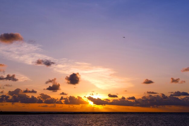 Heller, schöner Sonnenaufgang oder Sonnenuntergang am Meer. Naturschöner, heller Sonnenuntergang oder Sonnenaufgang über dem Meer, farbenfroher, dramatischer, majestätischer Landschaftshimmel mit erstaunlichen Wolken und Wellen am Sonnenuntergangshimmel