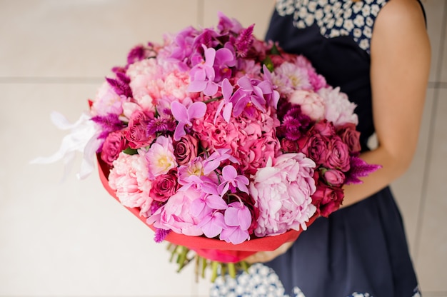 Heller und schöner Blumenstrauß von bunten Blumen in den Händen