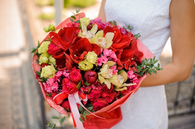 Heller und schöner Hochzeitsblumenstrauß in den Frauenhänden