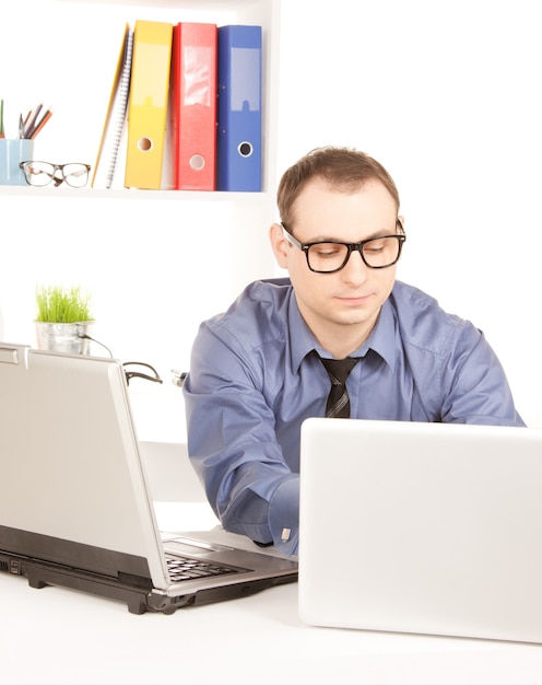 helles Bild des Geschäftsmannes mit Laptop-Computer im Büro