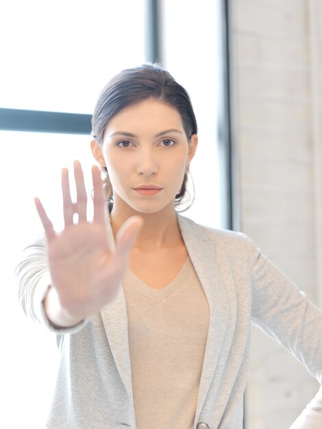 helles Bild einer jungen Frau, die eine Stoppgeste macht