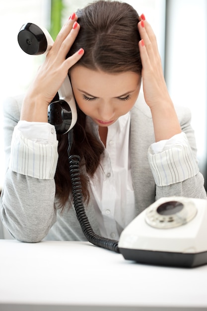 helles Bild einer traurigen Geschäftsfrau mit Telefon