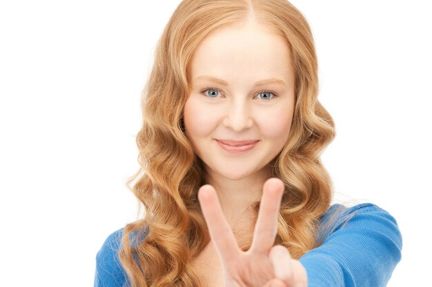 helles Bild eines schönen Teenager-Mädchens, das Victory-Zeichen zeigt