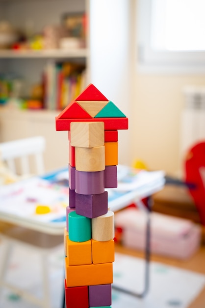 Helles buntes Holzblockspielzeug. Backsteinbauturm, Schloss, Kinderzimmer als