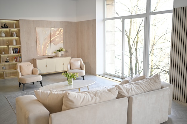 Helles klassisches modernes luxuriöses weißes Wohnzimmer im skandinavischen Stil mit Marmortisch, neuen stilvollen Möbeln, Kommode, gemütlichen Sesseln, beigem Sofa, Couch. Minimalistisches nordisches Innendesign