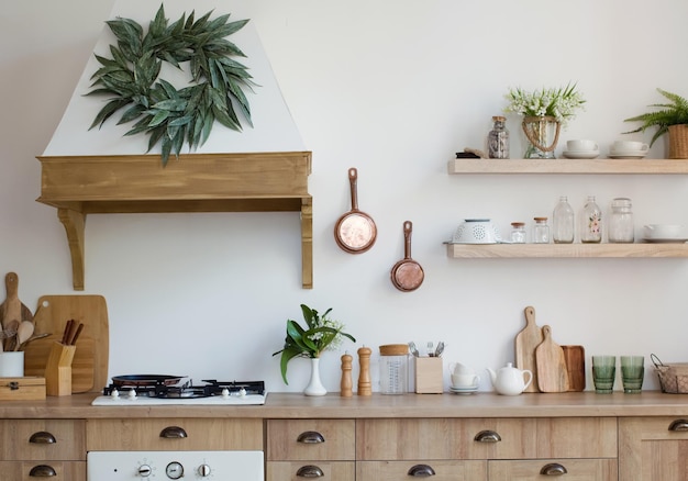 Helles Kücheninterieur aus Holz mit Küchenutensilien in den Regalen und an der Wand Schöne Kücheninnenausstattung