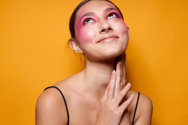 Helles Make-up der sexy Brunettefrau, die schwarzen Jersey lokalisierten Hintergrund unverändert aufwirft