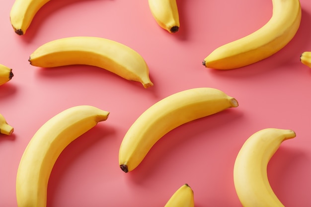 Helles Muster der gelben Bananen auf einem rosa Hintergrund.