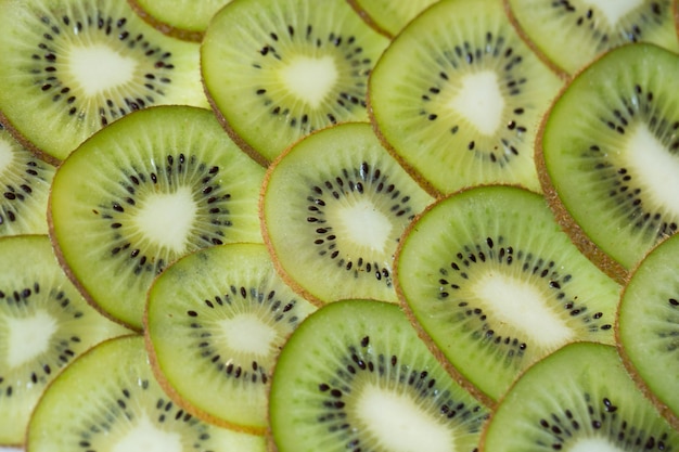 Hellgrüner Hintergrund mit Scheiben der saftigen Kiwi