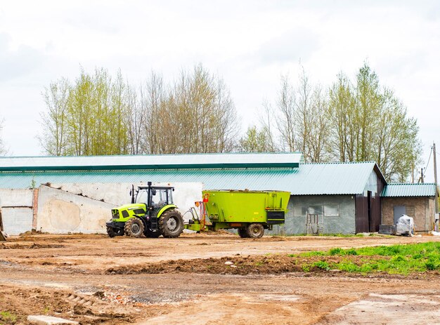 hellgrüner Traktor mit Anhänger auf dem Bauernhof