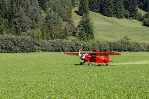 Hellrote Flugzeuglandung auf einer grünen Wiese, Transport, im Freien