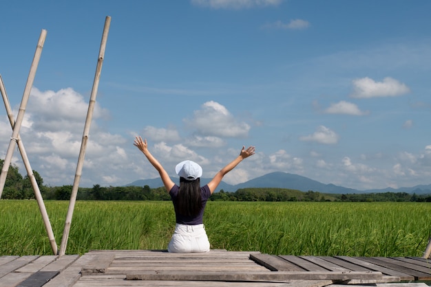 Foto hembra adolescente sentado en el puente de madera en el campo de arroz concepto diversión solo relajación viaje estilo de vida