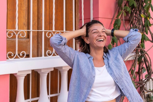 Foto hembra adulta feliz que despeina el cabello en la calle