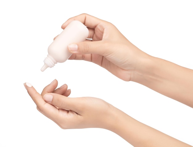 Hembra aplicando base líquida de maquillaje en la mano aislada sobre fondo blanco