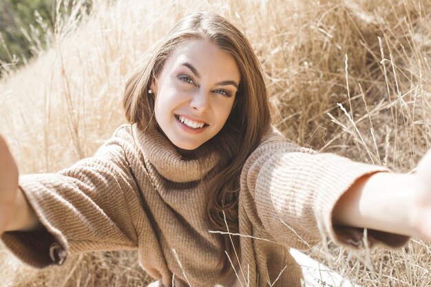 Hembra atractiva. Mujer joven al aire libre. Dama sobre fondo natural neutro. Chica alegre.