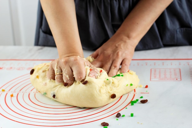 Hembra Baker Kenading masa de pan y panadería en cocina blanca proceso de horneado hacer pan de frutas