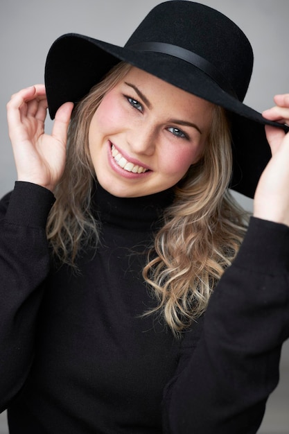 Hembra joven feliz con sombrero