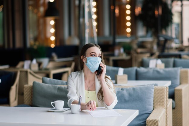 Hembra joven con máscara una cafetería