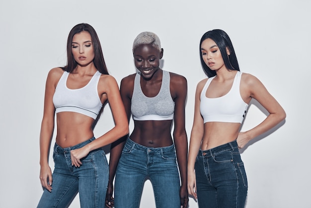 Hembras perfectas. Tres atractivas mujeres jóvenes mirando a la cámara y sonriendo