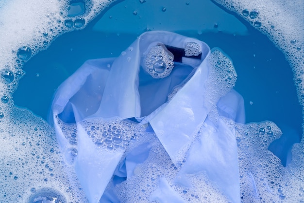 Hemd in Pulverreiniger Wasser auflösen, Tuch waschen. Wäschereikonzept.