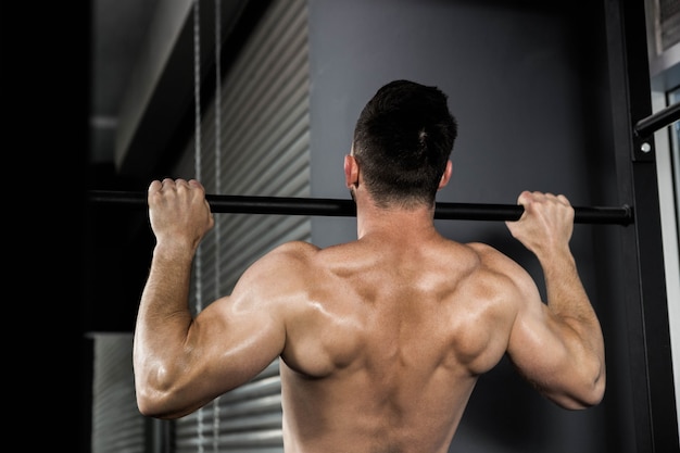 Hemdloser mann, den das handeln an der crossfit turnhalle hochzieht